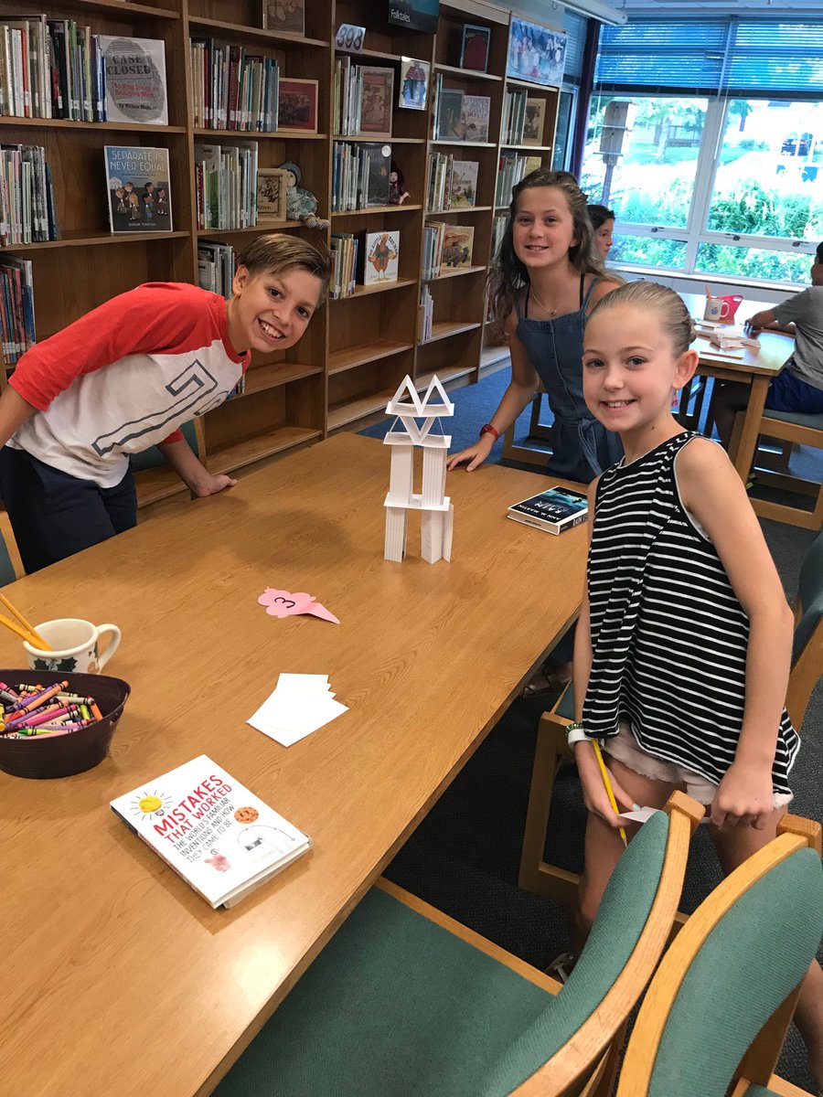 Creating literature towers in library ⁦<a href="/kris10shipp/">Kristen Jones</a>⁩