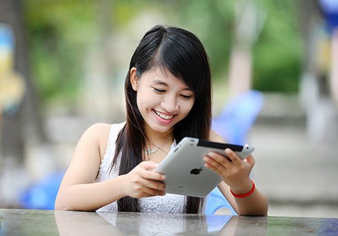 girl looking at ipad smiling