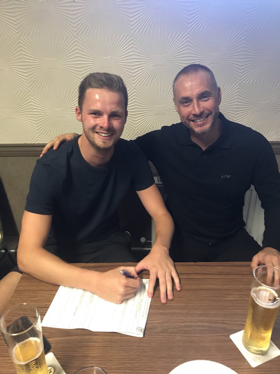 Goal keeper Josh Rowlands putting pen to paper
