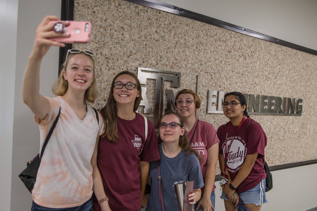 Five Aggies taking a photo in front of a Texas A&M Engineering sign