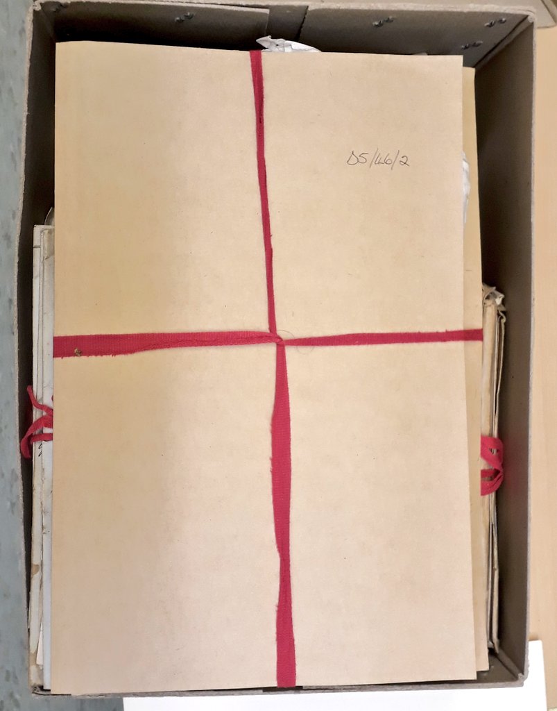 The folders are tied closed with cotton archival tape and inside one of the folders is an envelope containing a disposition written on a piece of vellum.