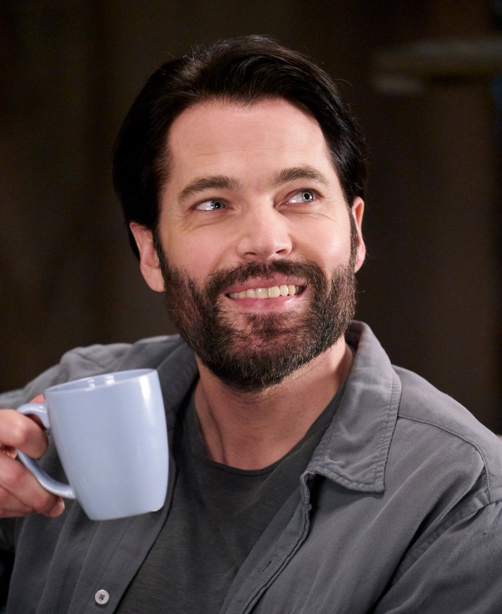 Tim Rozon as Mutt smiling with a mug of 'pine cone wine'. 