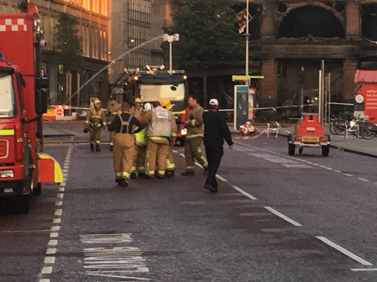 BBCNewsNI's tweet photo. UPDATE: Firefighters are still working to extinguish the Primark fire this morning as smoke continues to rise from the five-storey building in Belfast city centre. @BBCgmu is reporting live from the scene until 9am. https://t.co/QtkUTkLneI https://t.co/Ly7UQ2lXEk