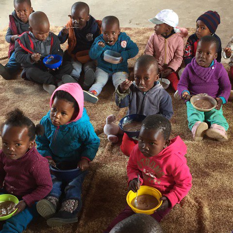TheLunchboxFund's tweet photo. Eastern Cape class listening intently over breakfast to their teacher reading them the lesson of the day. The chap in the middle in the blue windbreaker is going to be a doctor, according to him and his teacher. She says he is the brightest child she has ever taught. https://t.co/BakXnNnxwv