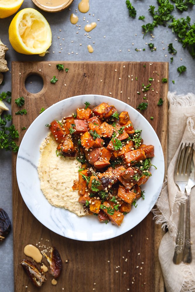 DeliciouslyElla's tweet image. Sticky peanut butter sweet potatoes, roasted with ginger, cinnamon and cumin and topped with sesame seeds and parsley on a bed of creamy hummus 😍 My idea of happiness in a bowl! P.136 of The Cookbook