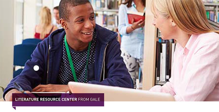 a black man and white woman smiling at each other over a computer sitting down at a library