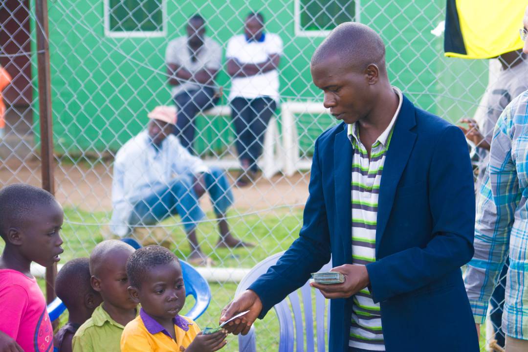 OnduparakaFC1's tweet photo. Every kid matters to us, our CEO giving out cash of 2000ugshs to the kids who came to watch our build up game @anfieldbhoy
@UniNhantsNews 
@UgandaEverton
@EITC 
@UgandaRedCross
@gedbyrne 
@BASW_UK
@singhzsz 

#AmaOnduparaka https://t.co/niqpvMFxVn