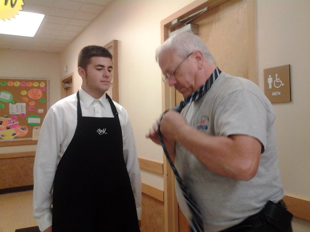 bigyfoods's tweet photo. We're better together! Bob from Facilities Management takes a minute to help one of our new employees, Jake, with making a tie on his first day. Nice job Bob! Thanks for the photo Jim! https://t.co/xMekAlOahA