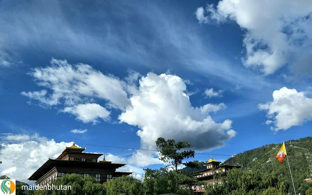 MaidenBhutan's tweet photo. The sun can be so relenting,  like today, but these clouds may bring in some respite this evening. A bit of the Tashichho Dzong,  and our flag flying high. 
#clouds@maidenbhutan .
#pure #monday #traveller #bhutan #instagood #believe #happiness #holiday #Vacations https://t.co/hvd2yyLKTI