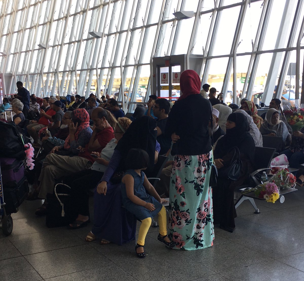 Anxious family at #JFK waiting for family to disembark quarantined #Emirates flight from #Dubai. A reported 100+ passengers got sick on the flight.