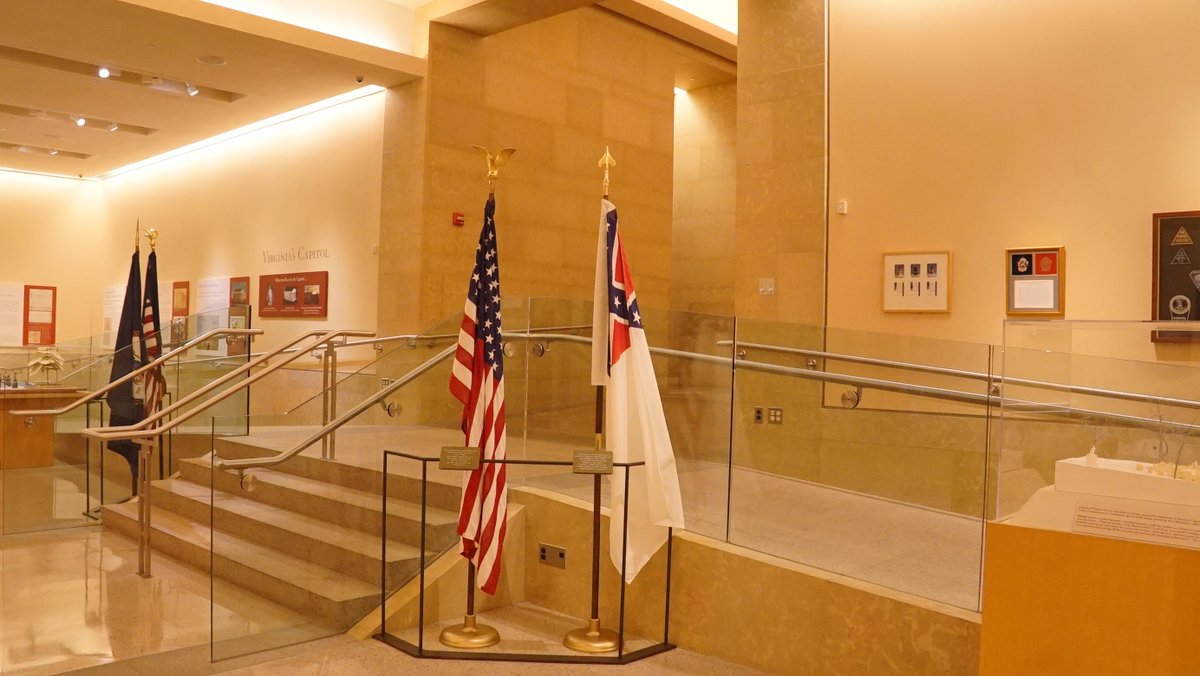 ProgressVA's tweet photo. We found racist propaganda at the Virginia Capitol Visitors Center. Why is the confederate flag placed alongside our US flag, with NO denunciation of #racism? Call Susan Schaar (Clerk of the Senate): 804- 698-7400 NOW. #NoHateSymbols #NoConfederateFlag https://t.co/73BCPRvVNa