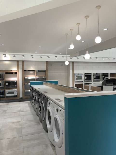 TRAILING | The Trail Appliances showroom has changed our perspective on laundry day....#BecauseGoodDesignIsGoodBusiness #commercialinteriordesign #interiordesign #laundry #showroom #teal #colour #woodtone #modern #update #renovation #kelowna #ylw #okanagan