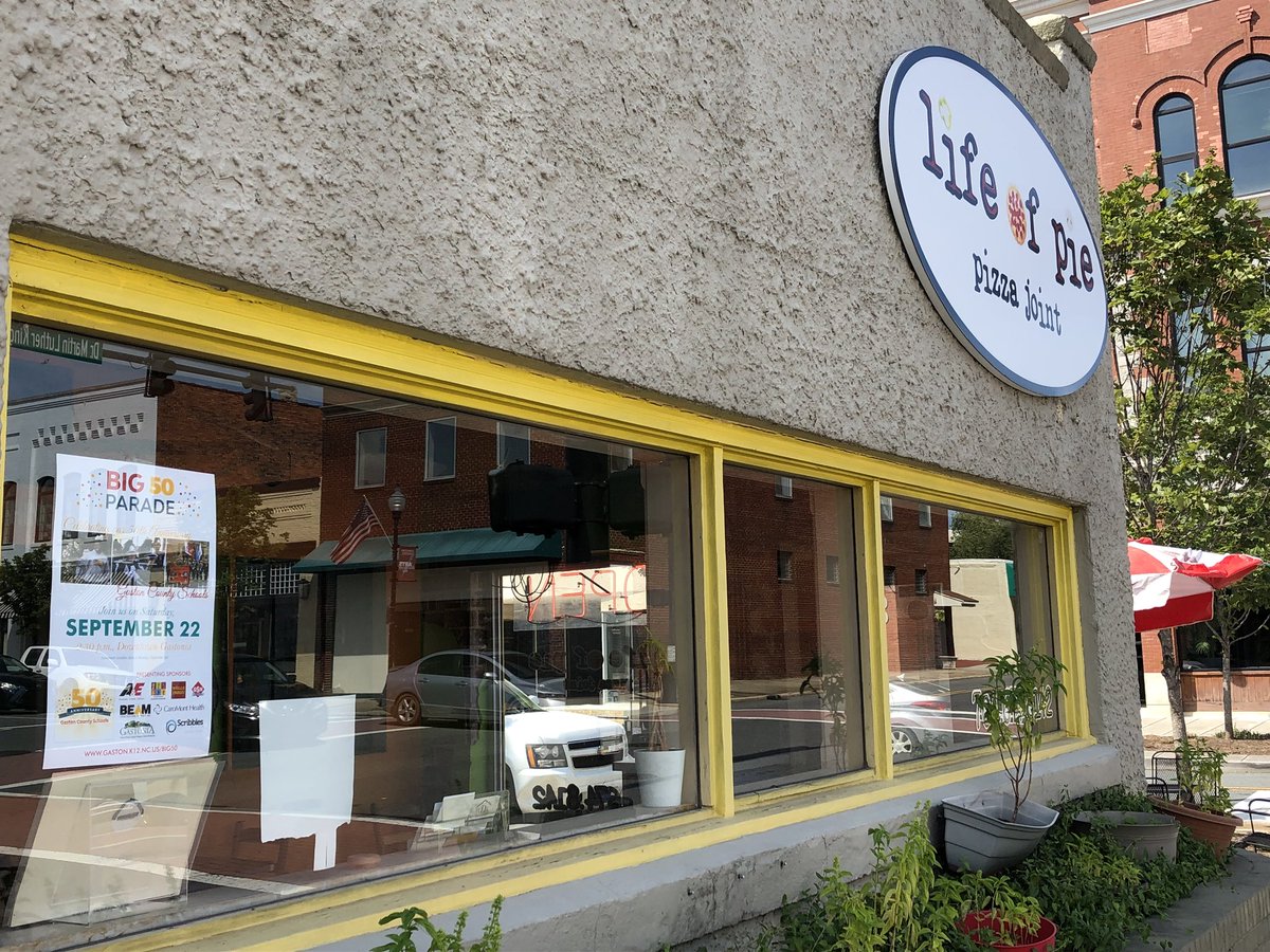 GastonSchools's tweet photo. Have you heard? We’re having a parade to celebrate the 50th anniversary of Gaston County Schools! Today we spotted one of our promotional posters hanging in the window of Life of Pie Pizza Joint in downtown Gastonia. https://t.co/4rKcL6BijR
