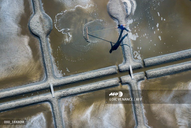 🇫🇷 An aerial picture shows a salt worker harvesting salt in Guerande.
📸 <a href="/LoicVenance/">Loïc Venance</a>