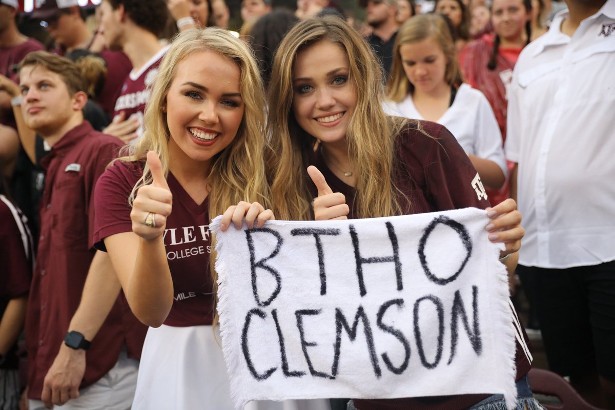 two aggie women holding a towel that says BTHO Clemson