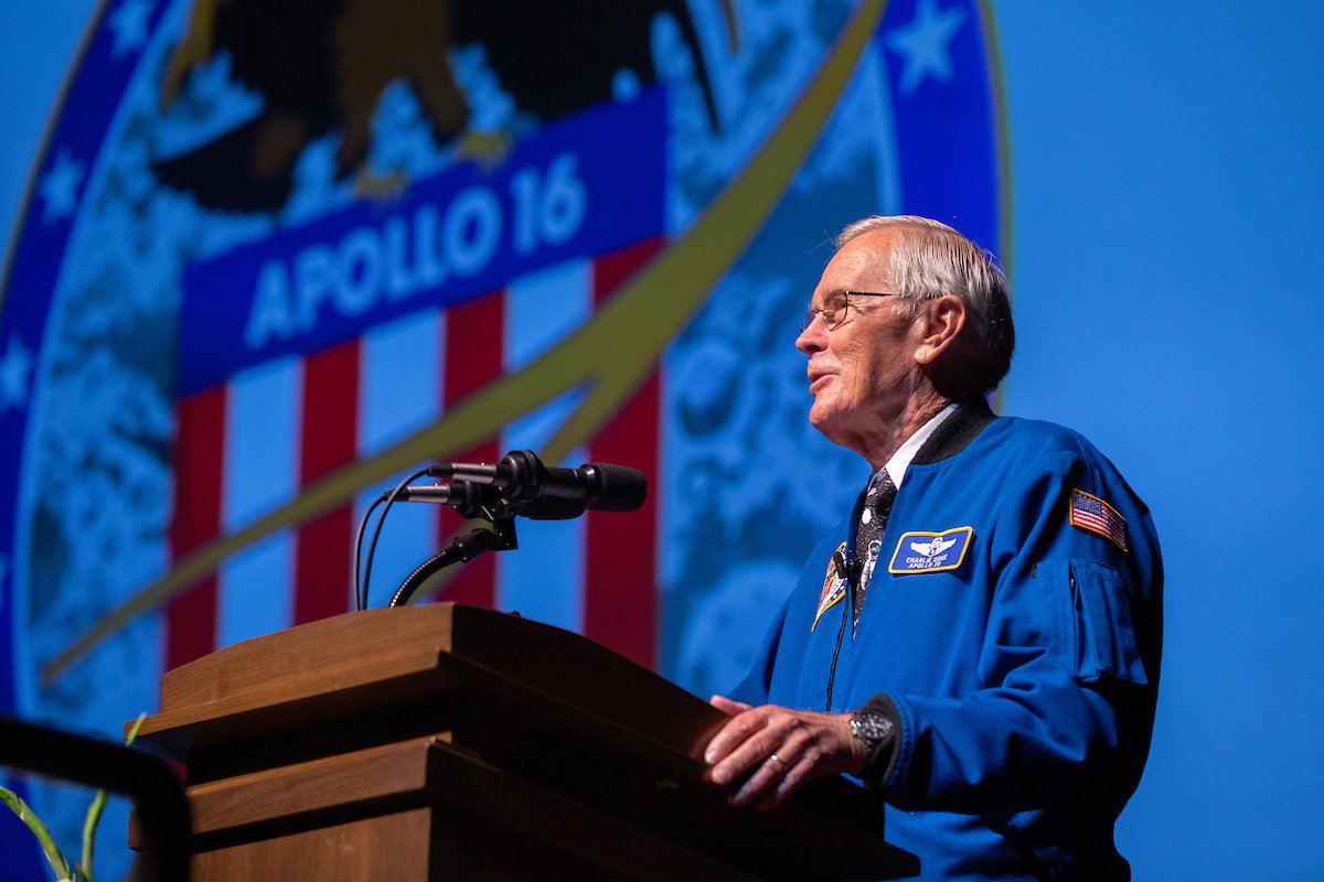 charlie duke standing behind a podium speaking