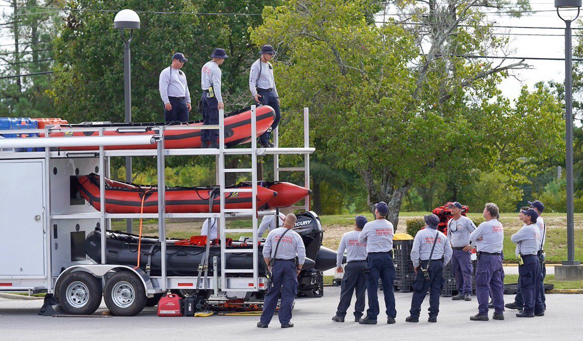 Men load rescue boats in stacks of three in large trailer