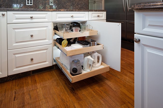 Store small appliances and bowls on glide-out shelving beneath your workable counter space to keep your counters clear when not in use. This way you can look at everything in the cabinet without having to move around all the items everytime you need something.