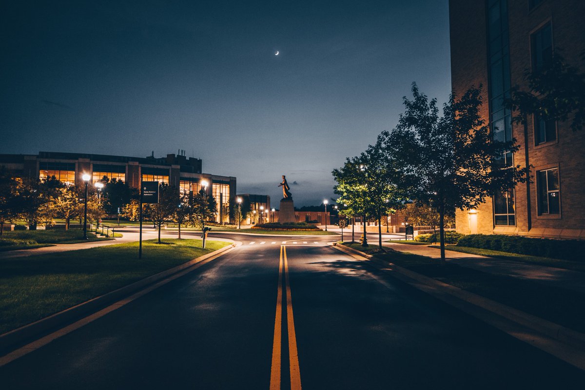 Statue of St. Francis Xavier on campus under a waxing crescent moon