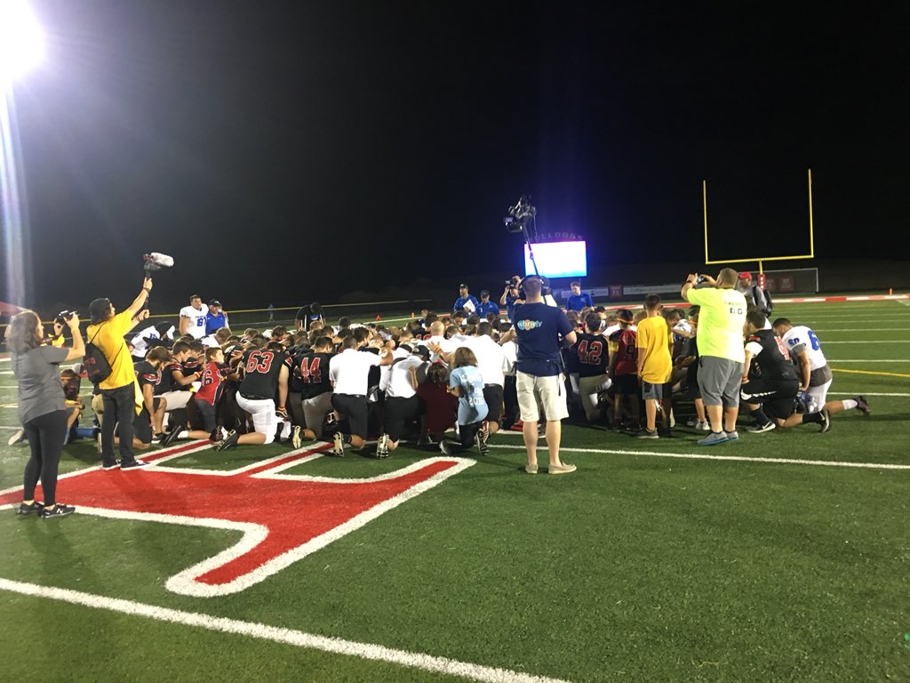 RomeoAthletics's tweet photo. After a 21-14 victory for the Dawgs, both teams come together midfield to show solidarity https://t.co/4oNGOuiyNx