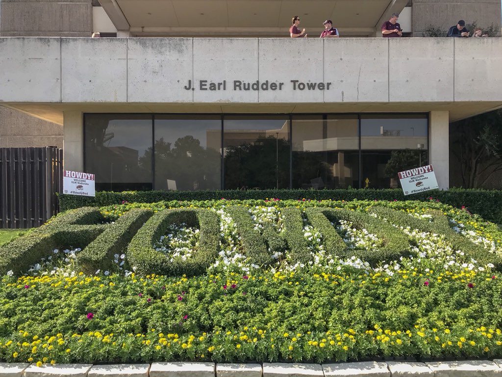 Bushes on campus in ULM colors that say Howdy