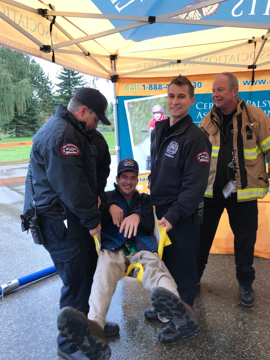 CPAlberta's tweet photo. These kind @EdmontonFire fighters offered to carry our very own Carlos so he would not miss out on the walk. With the weather so wet we were not sure of the path conditions and Carlos hasn't missed a walk in YEARS. #yeg #yegkindess #cerebralpalsy #lifewithoutlimits #lwlchallenge https://t.co/Rs1grdXkCE