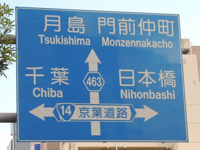 同じ交差点の昔の標識と今の標識。 古い青看板は路線番号や通称名を