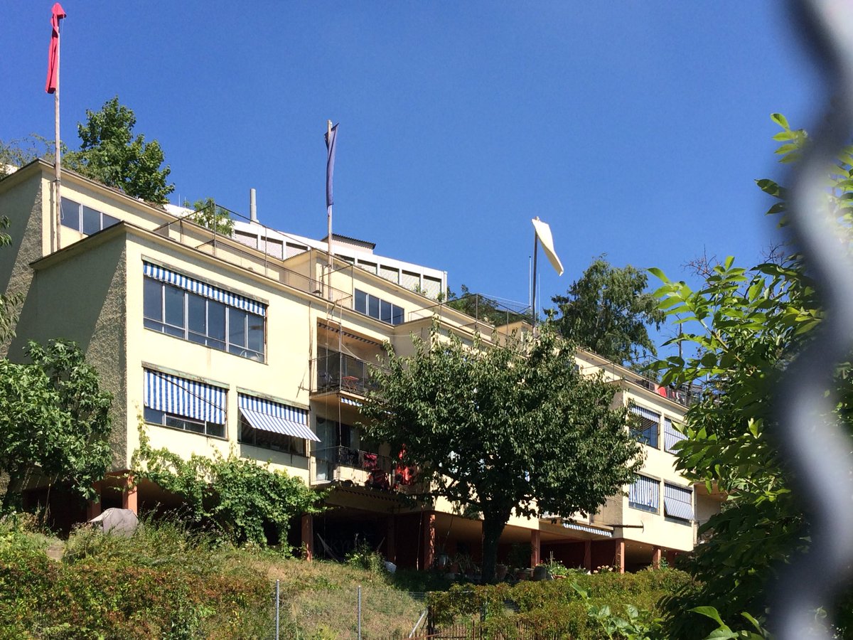 Annette_Hammer's tweet photo. #Rotachhäuser (1928-29) on Wasserwerkstrasse above river Limmat are exquisite #modernism in #Zurich! 3 cubes are set off against each other, one containing flats, the left ones are houses. The red pilotis reveal the conrete structure! #LeCorbusier https://t.co/cPzLPIfDMn