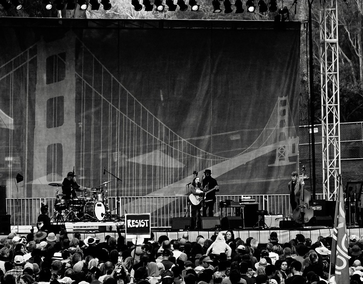 Someone holds a Resist sign as ‪Ani DiFranco‬ plays on the Tower of Gold Stage at Hardly Strictly Bluegrass in Golden Gate Park