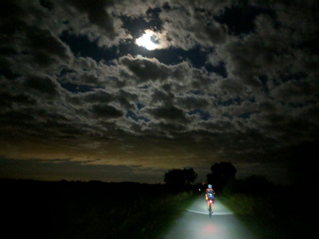 Amazing photo by John Kalblinger showing Jered Vaske riding the Raccoon River Valley Trail from Waukee past Dallas Center about 10 p.m. Tuesday, Sept. 25, under a full moon that was slipping in and out of the clouds.
