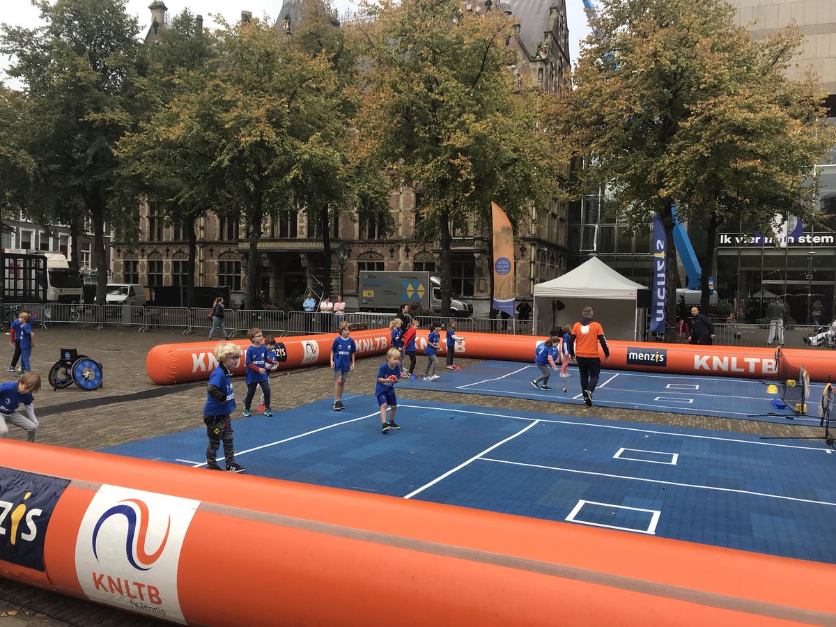 KNLTB's tweet photo. Het Plein in Den Haag is vandaag één grote tennisaccommodatie. Vandaag sluiten de KNLTB, de @GemeenteDenHaag en @Menzis het Tenniskids@School project af. De eerste kinderen zijn al volop in beweging #Tenniskids #HetPlein #DenHaag https://t.co/QhRiJ0CeIh