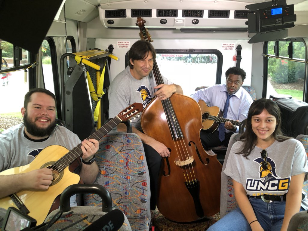 UNCG's tweet photo. Get on board: @UNCChancellor is kicking off @GTAHeat’s Tiny Bus Concert series! Joining him are @uncgarts Professor Steve Haines and students @Jaylo687 and Jessica Schneider. On the playlist: B.B. King, Buddy Guy and Van Morrison.  #TinyBusGSO #UNCGWay @greensborocity https://t.co/B7iY2X8zdX