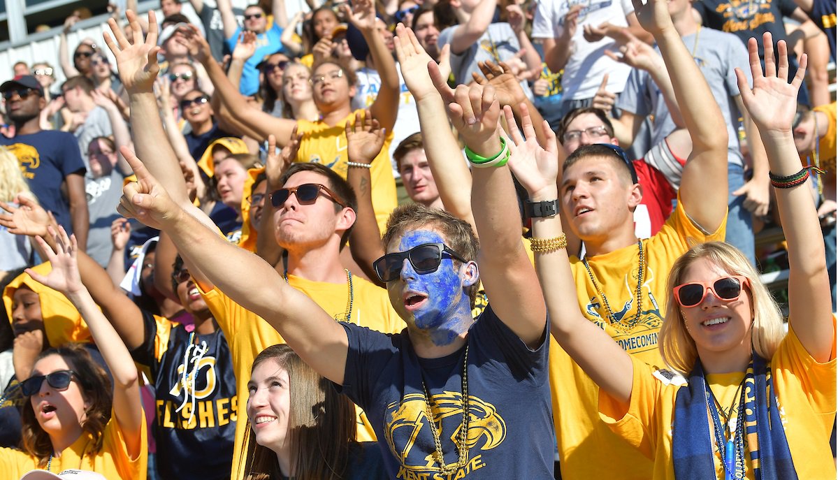 Kent State University students attempt to get the attention of cheerleaders who were throwing T-shirts into the crowd during the Homecoming football game.