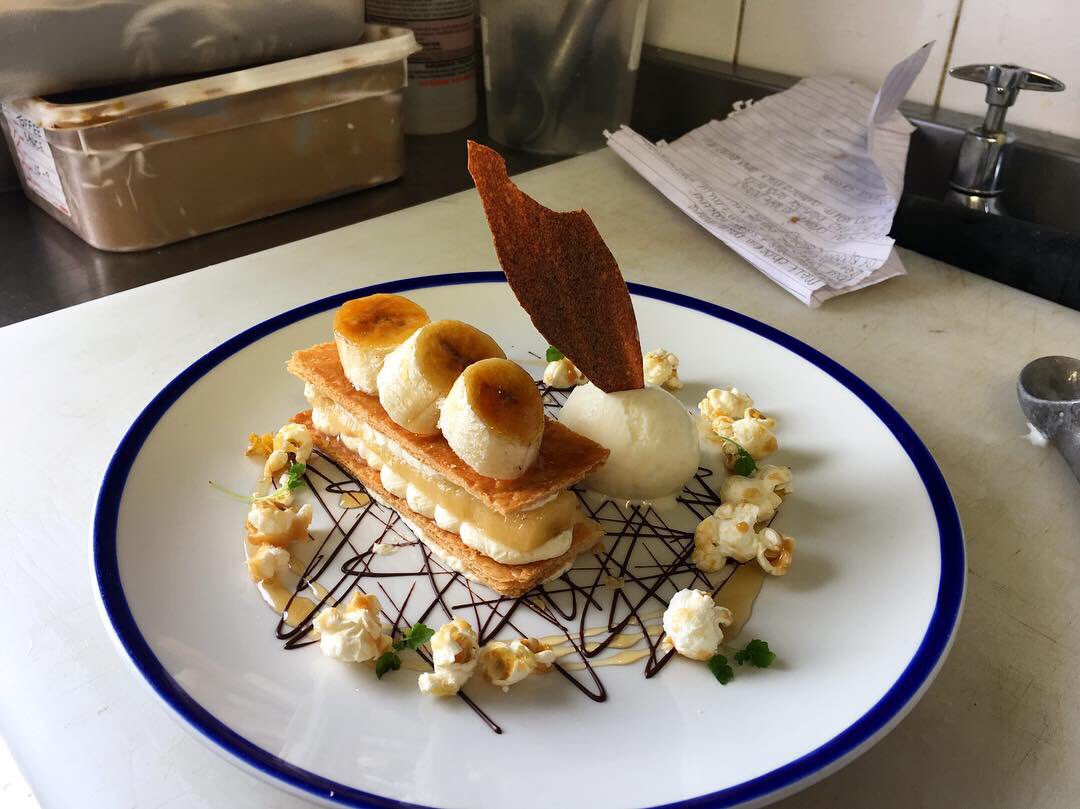 Poached Banana Mille-Feuille 
Vanilla Chantily
Caramelised Banana
Toffee Popcorn
Banana Tuile
Chocolate 
Honey Ginger Ice cream
Maple Syrup