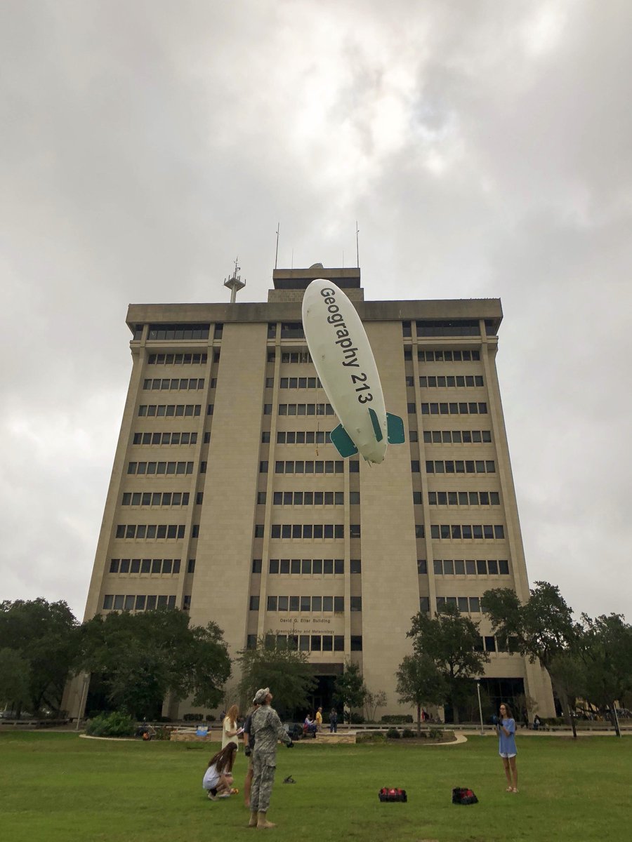 students flying a blimp outside of the O&M building