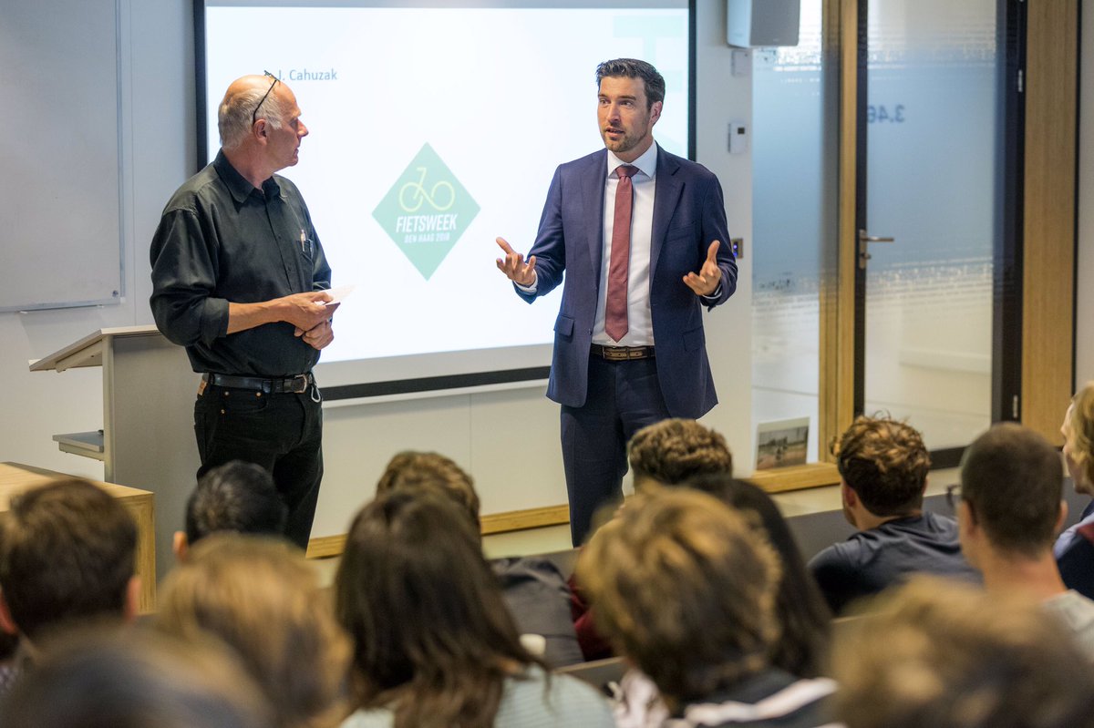 Newsroom070's tweet photo. Studenten van de Haagse Hogeschool en wethouder @RvanAsten gingen tijdens een hoorcollege vanmiddag met elkaar in gesprek over verkeersveiligheid. De studenten presenteerden creatieve en slimme oplossingen om het voor de groeiende groep fietsers veilig te houden #denhaagfietst https://t.co/Zkw5VILgYG