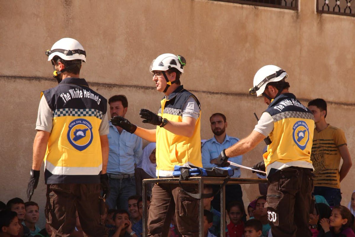 SyriaCivilDef's tweet photo. The Syrian Civil Defense continues their campaign of incorporating health and safety awareness with fun and games for students. The latest visit was made to the children of Abu Bakr Al-Razi School in the town of #Harbnoosh, in #Idlib countryside. #WhiteHelmets #Syria https://t.co/cOQJ6I8ALb