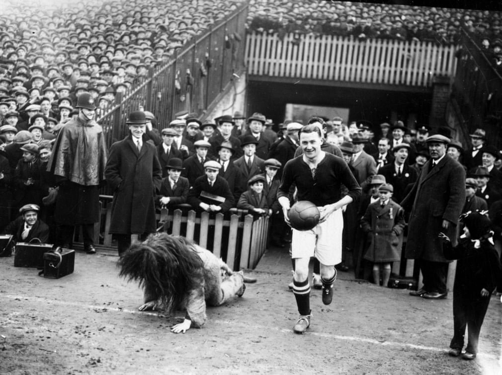 robertmdaws's tweet photo. #MillwallFC captain, #LenGraham, fails to conceal his amusement as he leads his team out at #theDen and #Zampa the Lion falls over  
 Photograph: H. F. Davis/Getty Images @MillwallFC https://t.co/I5qhYdRJX6
