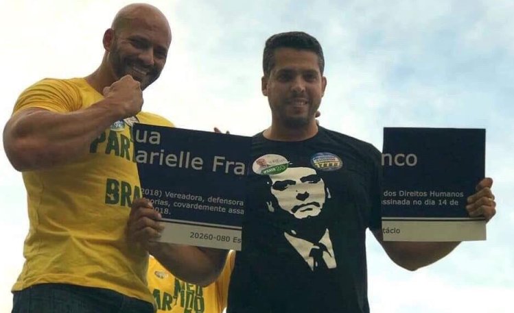 Três idiotas aparecem em foto quebrando placa que homenageava Marielle Franco no Rio de Janeiro. Um deles com camiseta que estampa o rosto do único candidato que não lamentou a execução da vereadora.