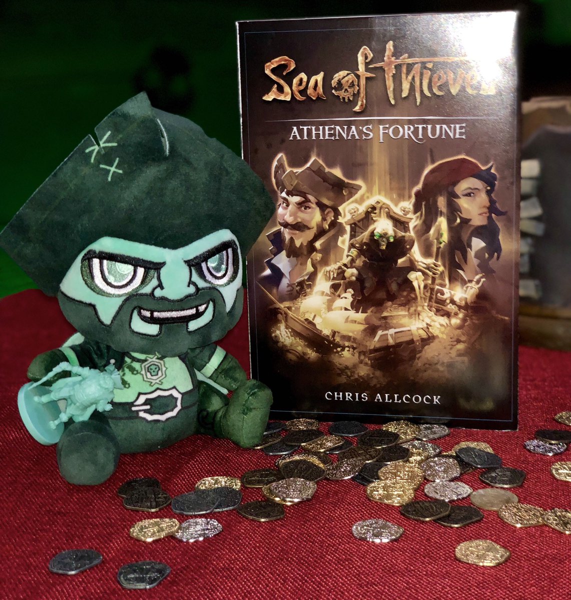 Pirate Lord Stubbins plushie alongside a copy of Sea of Thieves novel Athena'a Fortune