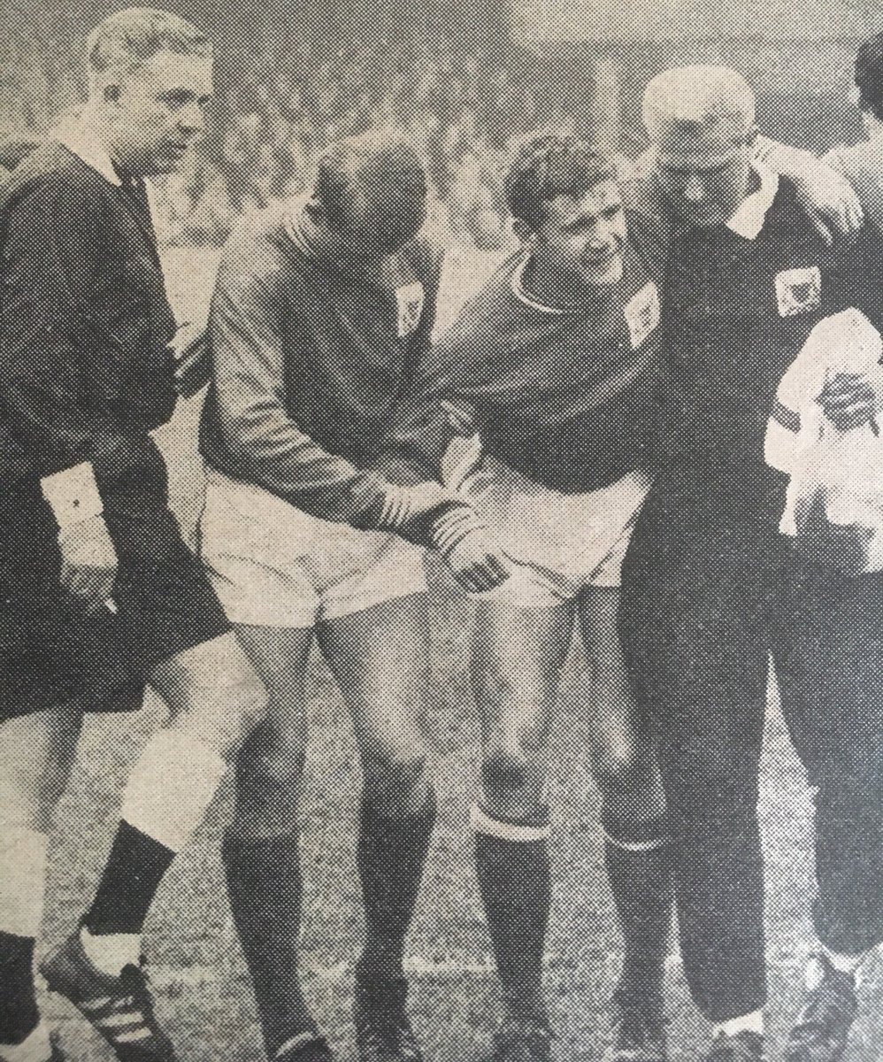Joe Baker of Nottingham Forest is helped off the pitch by teammate John Barnwell and trainer Tom Cavanagh after injuring his knee against Everton