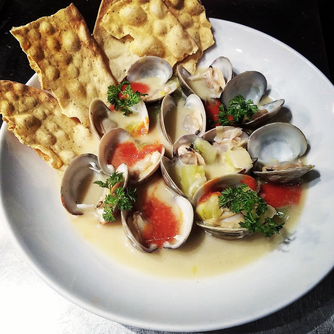 Now on the dinner menu! Little Neck clams, fumet, creamy, leeks, red pepper coulis, Old Bay cracker.