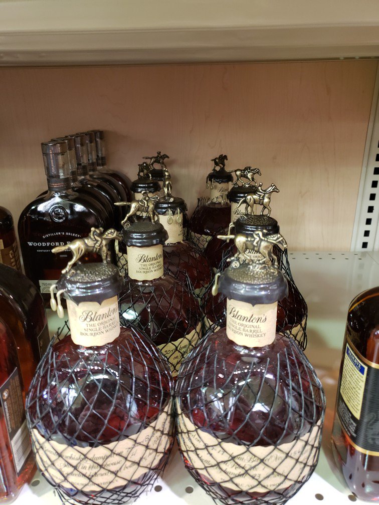 TrevHancock's tweet photo. ENTIRELY unfair: not a drop to be found in #Charlotte, NC but look at the shelf full of #Blanton's in #Gander, NL. Some of it is even dusty!! https://t.co/QrVfXsmQPf