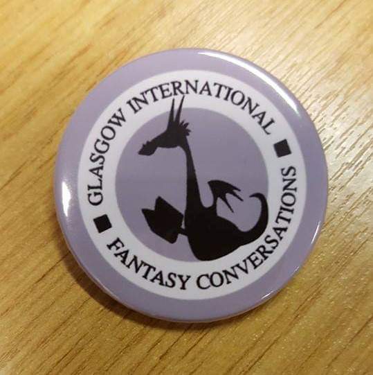 The GIFCon logo, designed by Kat Ward, presented on a badge on a table.