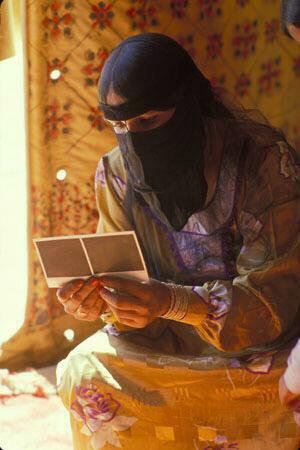 صورة جميلة لـ أمرأة من البادية تشاهد صور التُقطت لها بواسطة كاميرة فورية عام  ١٩٧٨م .. قبل ٤٠ سنة تقريباً ..