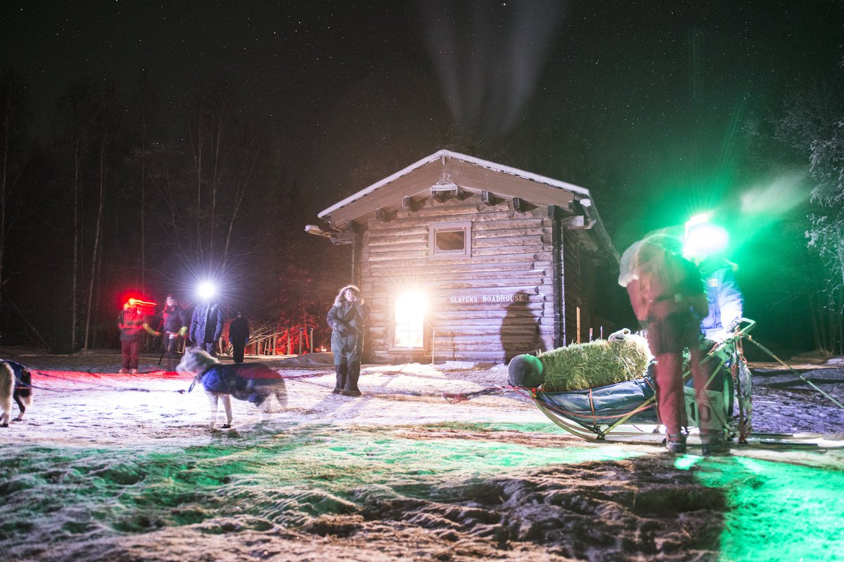small building at night with dogsled out front