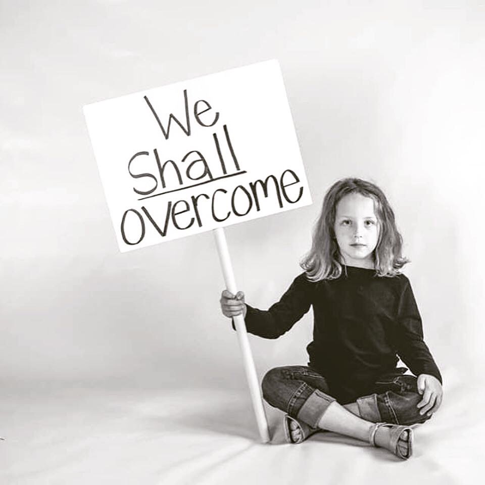 VoicesofHopeNE's tweet photo. Women's rights activist Gloria Steinem posed for LIFE magazine in 1965 to remind us that no matter the obstacles that stand between us and equality, "we shall overcome." Today Everly, granddaughter of a staff member, poses with the same message, just relevant today as in 1965. https://t.co/63YVwTXyYh