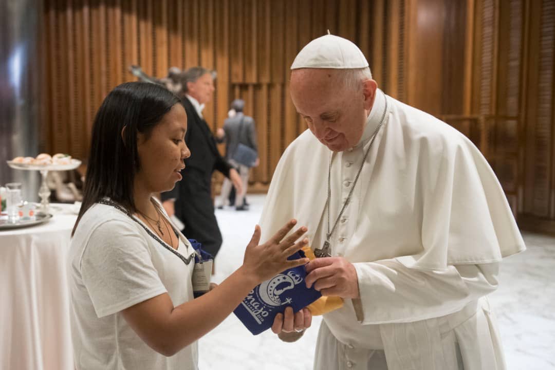 El Papa Francisco recibe de manos de la Auditora venezolana, el kit del 4to Encuentro Nacional de Jóvenes y la franela de voluntarios. Venezuela presente en el Sínodo.