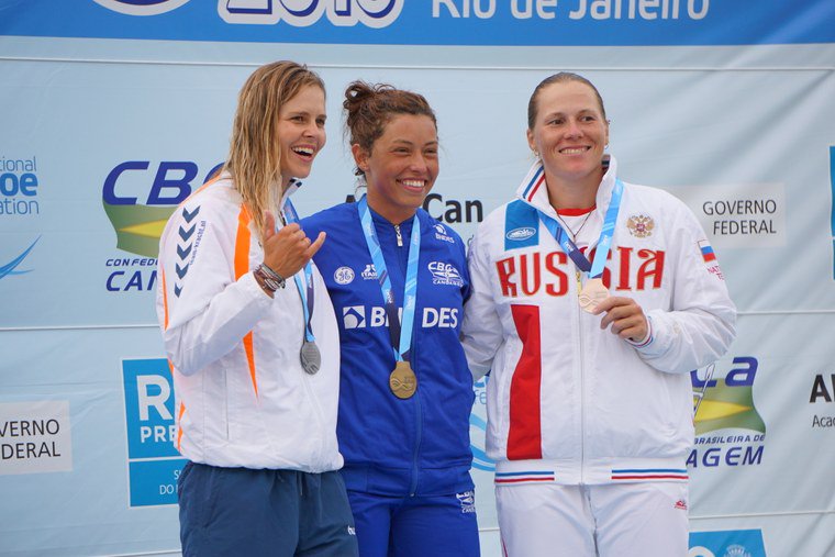 Three athletes pose for the picture. The women are wearing medals and the Brazilian is in the middle.