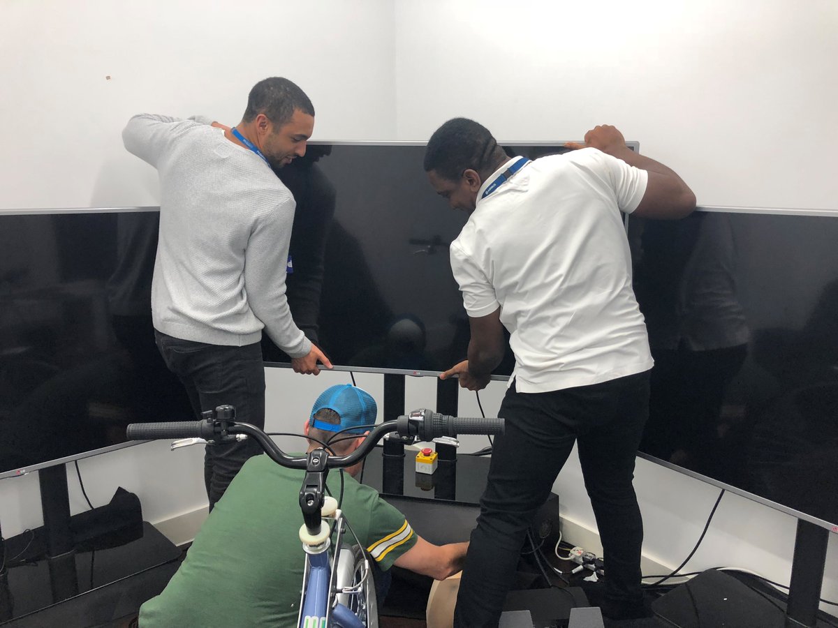 SIMUSAFE's tweet photo. The @CovUni_FTC team is busy setting up monitors for the bike simulator. Excited to see the @_ITCL environment on the big screens! #H2020 #simulation #transport #vulnerableusers https://t.co/eGAwzSX1Cv